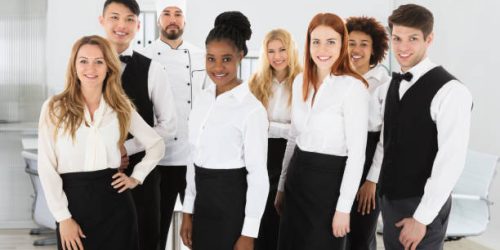 Portrait Of Confident Restaurant Staff Standing Against White Background